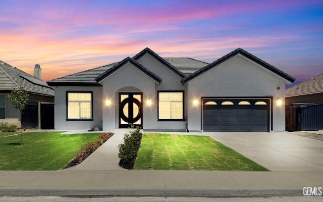 view of front of property with a lawn and a garage