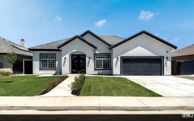 ranch-style home with a garage and a front lawn