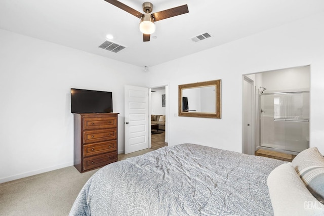 bedroom with ceiling fan, ensuite bathroom, and light carpet