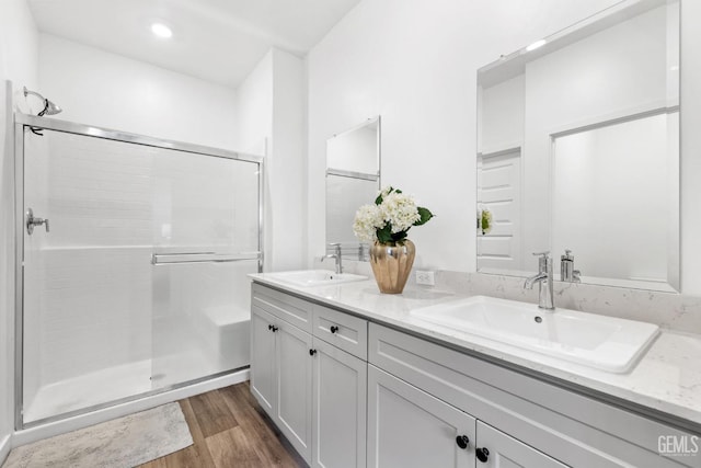 bathroom featuring hardwood / wood-style flooring, vanity, and an enclosed shower