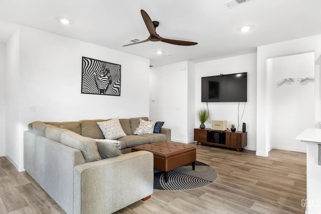 living room featuring light hardwood / wood-style flooring and ceiling fan