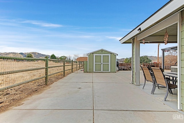 view of patio / terrace featuring a mountain view and a storage shed