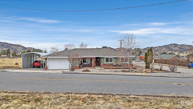 ranch-style home with a mountain view, a garage, and a carport