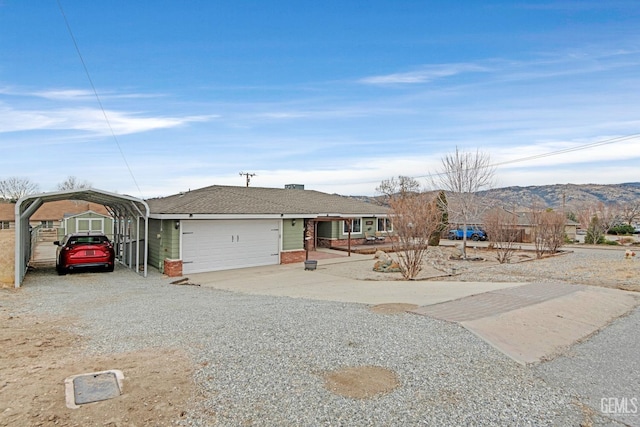 view of front of property with a carport, a mountain view, and a garage