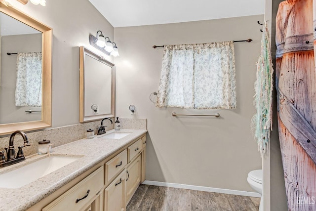 bathroom with hardwood / wood-style floors, vanity, and toilet