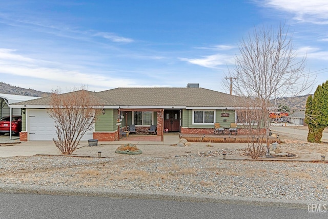 ranch-style home featuring covered porch, a garage, and a carport