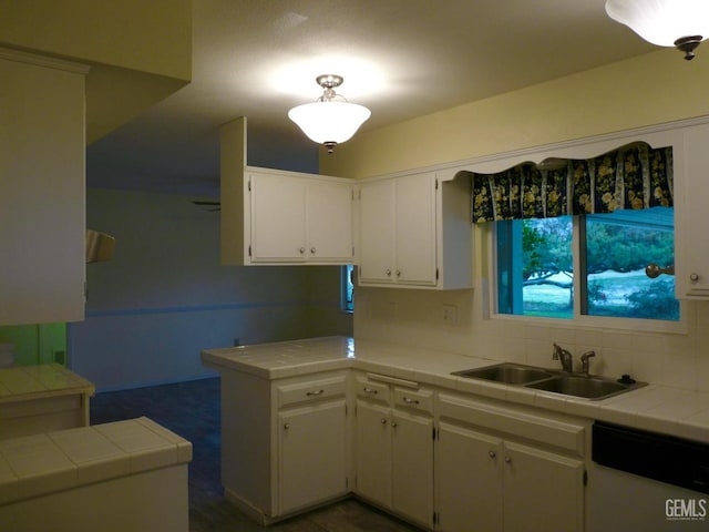 kitchen featuring sink, dishwasher, white cabinets, tile countertops, and kitchen peninsula