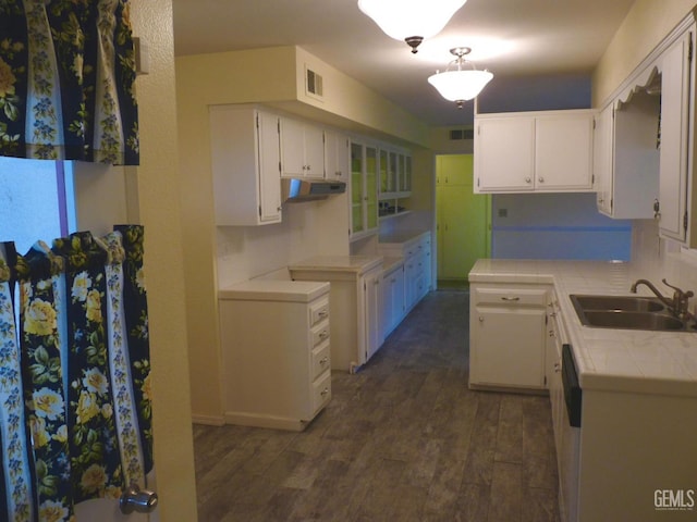 kitchen with sink, tile countertops, dark hardwood / wood-style floors, and white cabinets