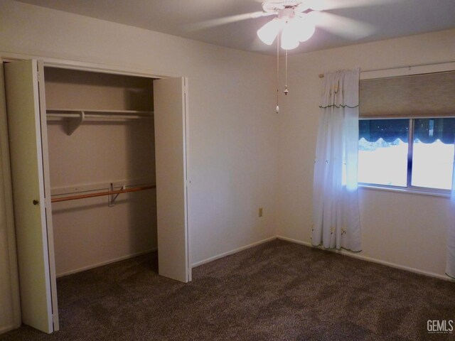 unfurnished bedroom with dark carpet, a closet, and ceiling fan