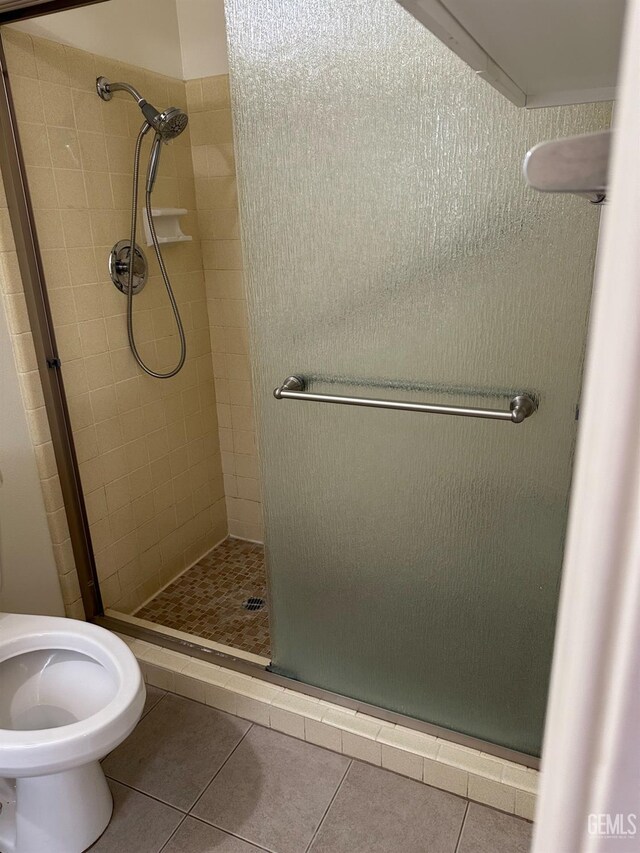 bathroom featuring an enclosed shower and tile patterned flooring