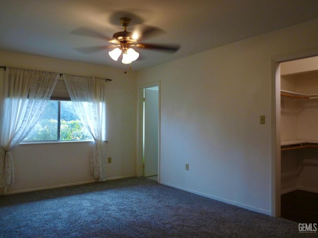 unfurnished bedroom with ceiling fan, a spacious closet, carpet floors, and a closet