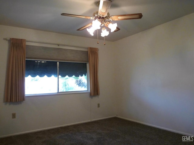 spare room featuring dark colored carpet and ceiling fan