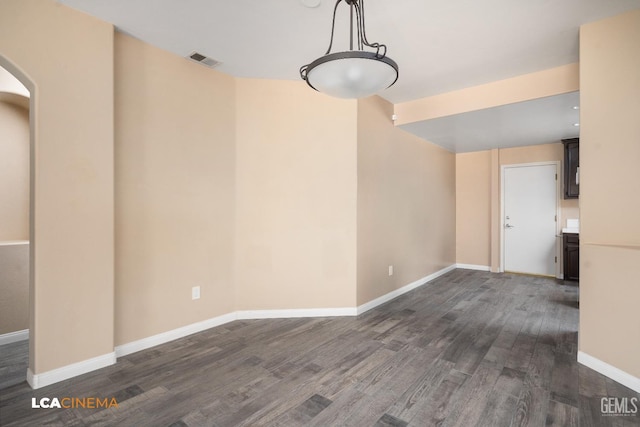 5502 White Pine Way, Bakersfield, CA 93313 - unfurnished dining area featuring dark wood-style floors, baseboards, and arched walkways