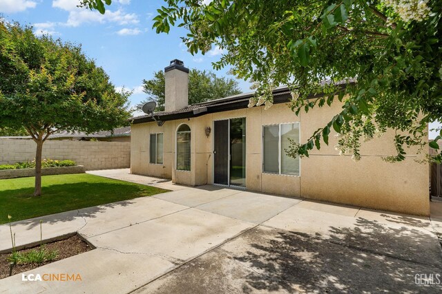 5502 White Pine Way, Bakersfield, CA 93313 - back of property with stucco siding, a chimney, and a patio area