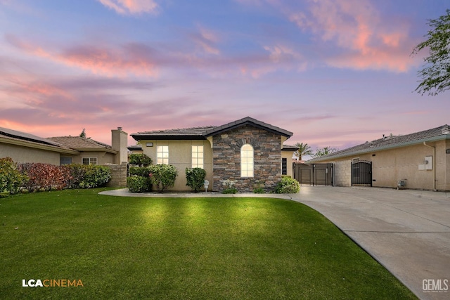 5502 White Pine Way, Bakersfield, CA 93313 - view of front of house featuring a gate, a lawn, stone siding, stucco siding, and driveway