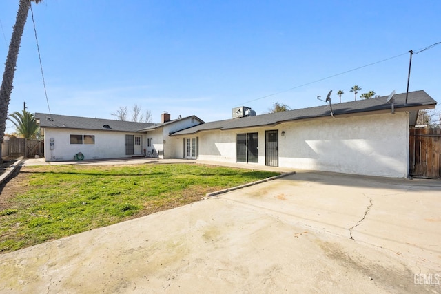 view of front of home with a patio, a front yard, fence, and stucco siding