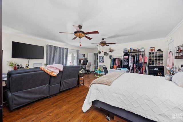 bedroom featuring dark wood-type flooring, a ceiling fan, and crown molding