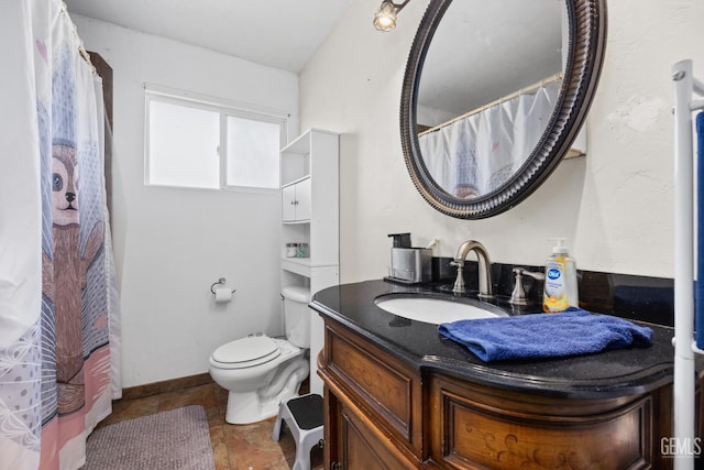 bathroom featuring baseboards, vanity, and toilet