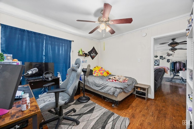 bedroom featuring dark wood-type flooring, crown molding, and a ceiling fan