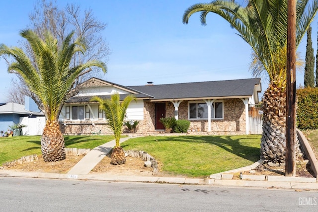 view of front facade with stone siding and a front lawn