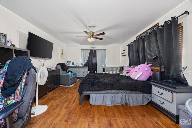 bedroom with visible vents, ceiling fan, and wood finished floors