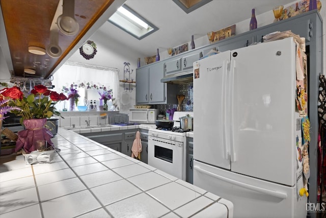 6009 Cedar Glen Ln, Bakersfield, CA 93313 - kitchen with tile counters, white appliances, under cabinet range hood, and backsplash