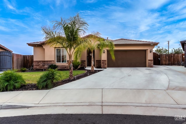 8907 Stevie Ct, Bakersfield, CA 93313 - view of front facade featuring stone siding, stucco siding, a garage, and driveway