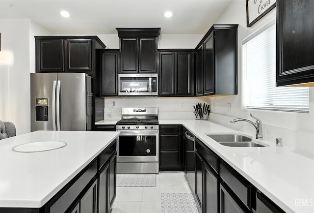 8907 Stevie Ct, Bakersfield, CA 93313 - kitchen with stainless steel appliances, dark cabinetry, light tile patterned flooring, light countertops, and recessed lighting