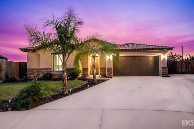 8907 Stevie Ct, Bakersfield, CA 93313 - view of front of house with stone siding, a garage, driveway, and stucco siding