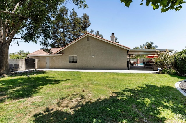 812 Mazatlan Dr, Bakersfield, CA 93314 - view of home's exterior with stucco siding, a chimney, a patio, and a tiled roof