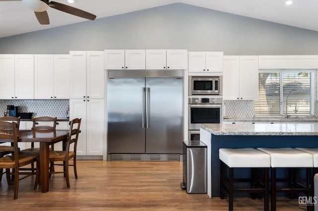 812 Mazatlan Dr, Bakersfield, CA 93314 - kitchen featuring built in appliances, high vaulted ceiling, a kitchen breakfast bar, white cabinetry, and ceiling fan