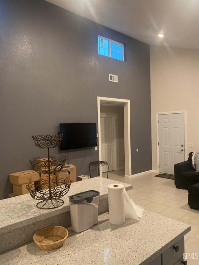 tiled living room featuring a high ceiling