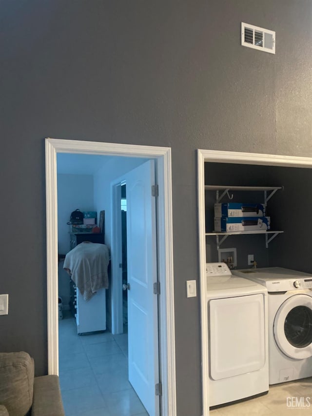 laundry area featuring light tile patterned floors and independent washer and dryer