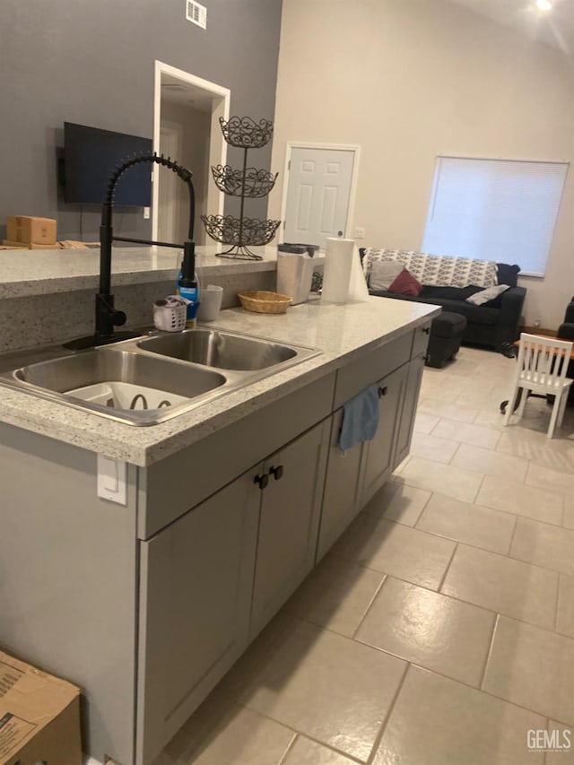 kitchen featuring gray cabinets, light tile patterned floors, and sink