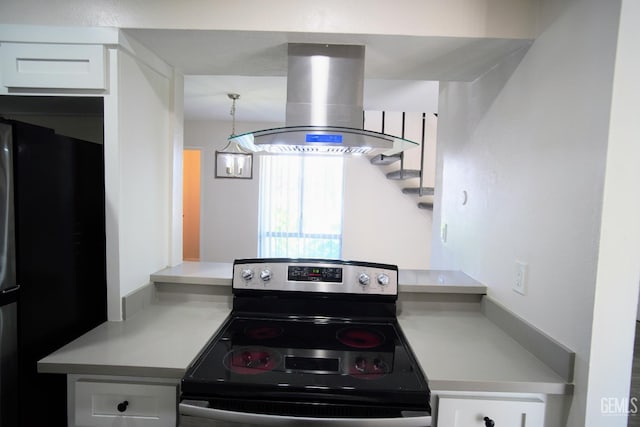 4801 Belle Ter Unit C, Bakersfield, CA 93309 - kitchen with island range hood, stainless steel electric stove, white cabinets, freestanding refrigerator, and light countertops
