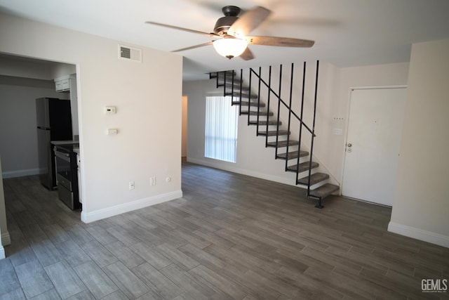 4801 Belle Ter Unit C, Bakersfield, CA 93309 - unfurnished living room with a ceiling fan, stairs, and dark wood-style flooring