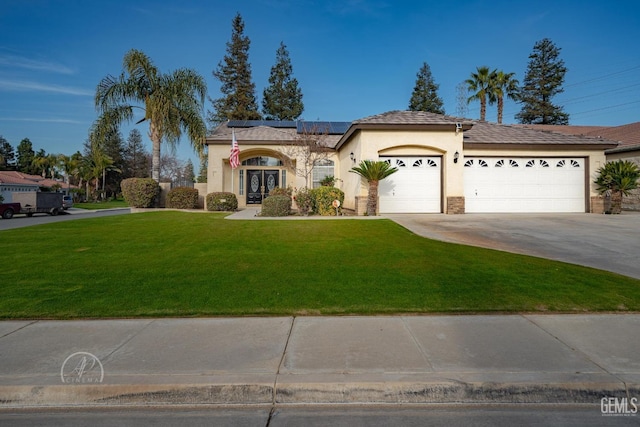 ranch-style house featuring solar panels, a garage, and a front lawn