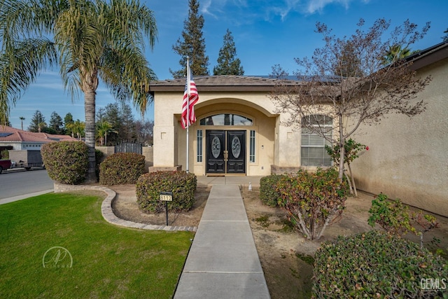 property entrance with a lawn and french doors