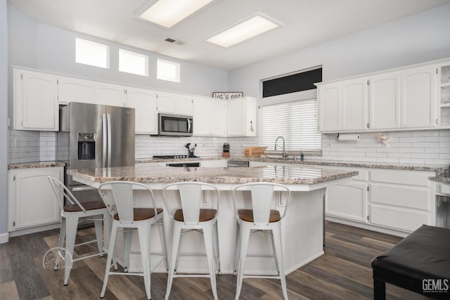 kitchen with white cabinets, a center island, and stainless steel appliances