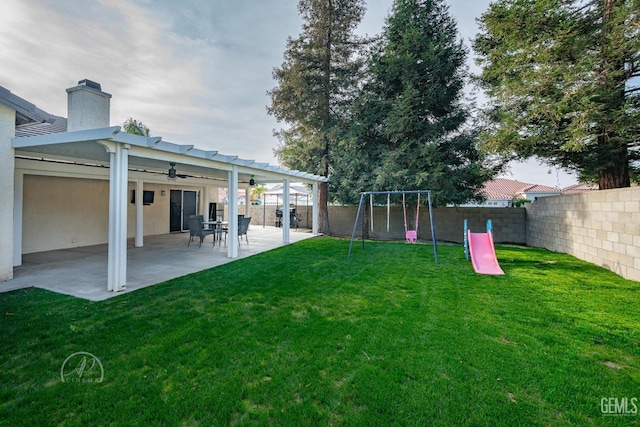 view of yard with a playground, a patio area, and ceiling fan