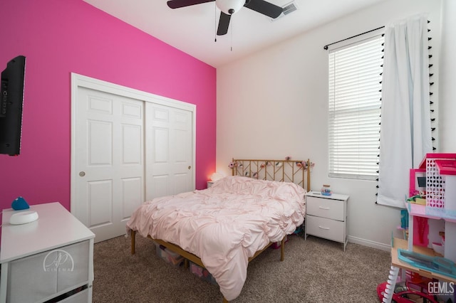 carpeted bedroom featuring multiple windows, ceiling fan, and a closet