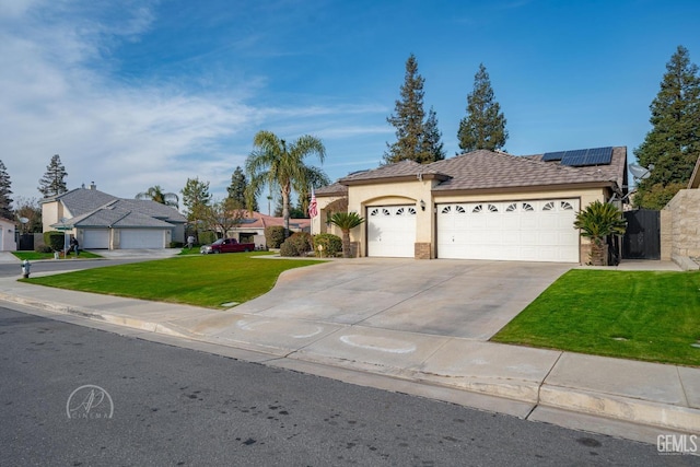 ranch-style home with solar panels, a front lawn, and a garage