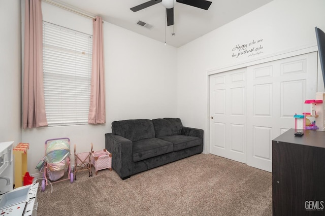 living area with carpet and ceiling fan