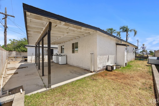 2110 Center St, Bakersfield, CA 93305 - rear view of property with washing machine and clothes dryer, a fenced backyard, a patio area, and stucco siding