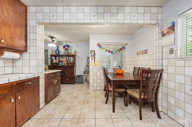 2110 Center St, Bakersfield, CA 93305 - dining space featuring tile walls, ceiling fan, and light tile patterned floors