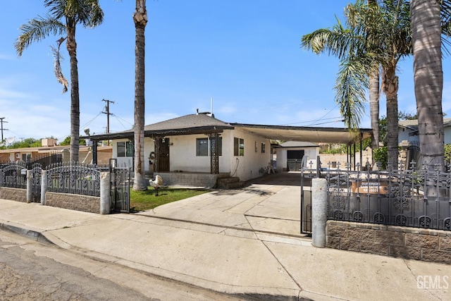 2110 Center St, Bakersfield, CA 93305 - view of front of house with concrete driveway, a fenced front yard, a carport, and stucco siding