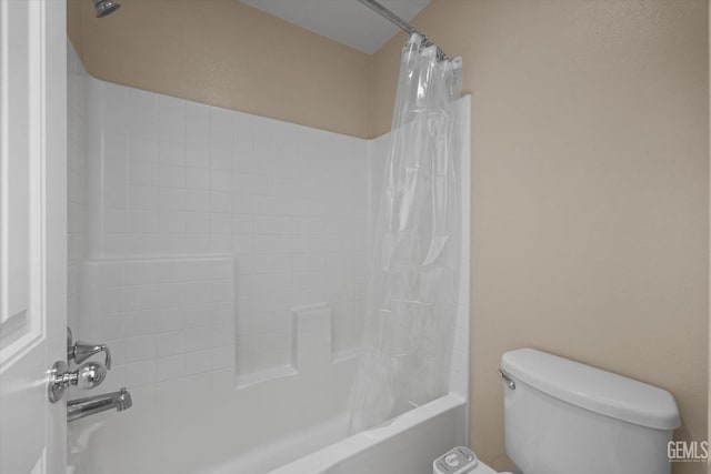 bathroom featuring toilet and shower / bath combination with curtain