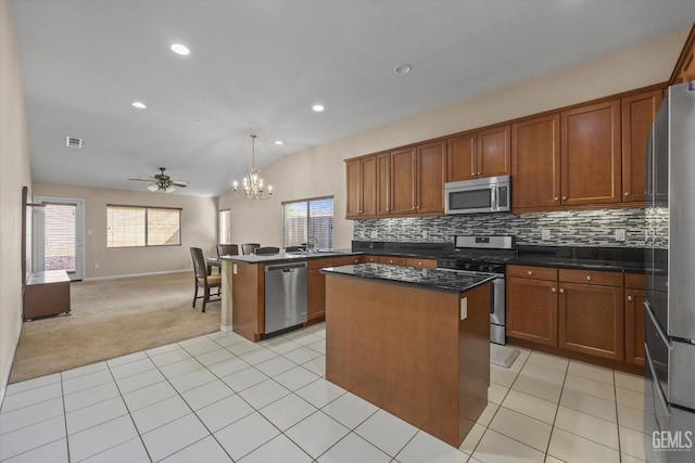 kitchen featuring hanging light fixtures, appliances with stainless steel finishes, open floor plan, and a center island