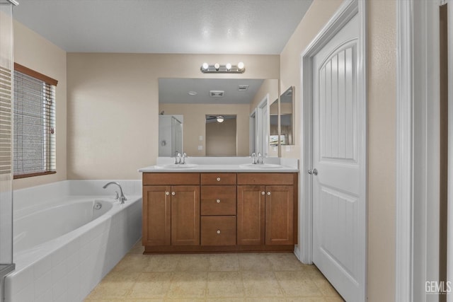 full bathroom with double vanity, a garden tub, a shower stall, and a sink