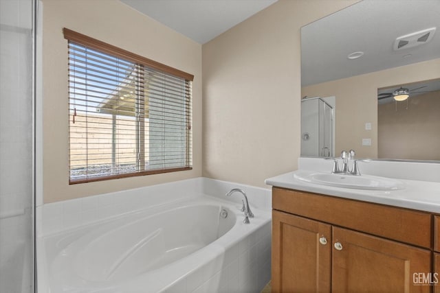 bathroom with ceiling fan, a garden tub, vanity, visible vents, and a stall shower